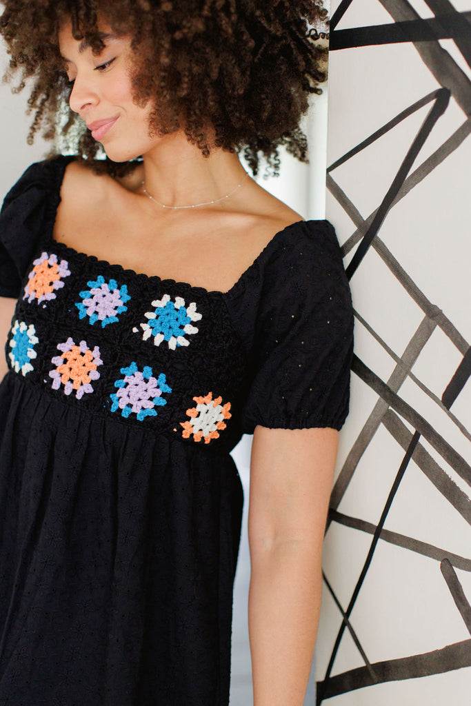 Black mini dress with puff sleeve and crochet floral detail