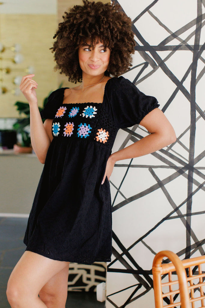 Black mini dress with puff sleeve and crochet floral detail