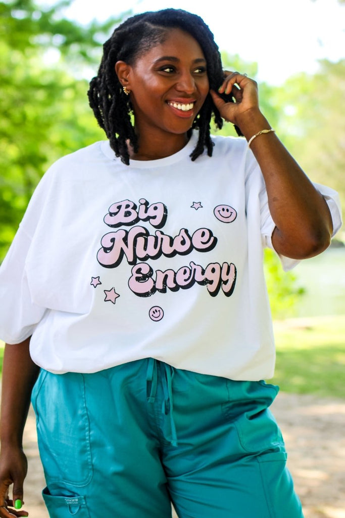 White tee with "Big Nurse Energy" in bubble letters in pink 