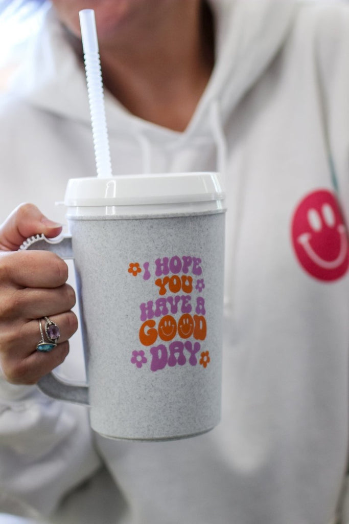 22 oz mega mug with lid and straw with the phrase "I hope you have a good day" in purple and orange