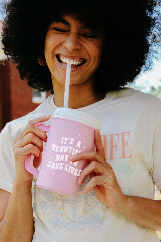 Light pink 22 oz plastic mega mug with lid and straw with quote "It's A Beautiful Day to Save Lives" in white 