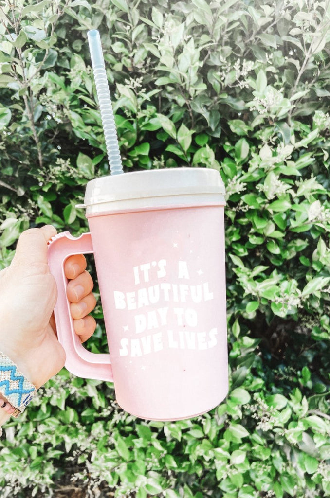 Light pink 22 oz plastic mega mug with lid and straw with quote "It's A Beautiful Day to Save Lives" in white 