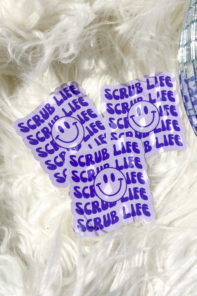 Light purple sticker with dark purple "scrub life" repeating with a smiley face in the center 