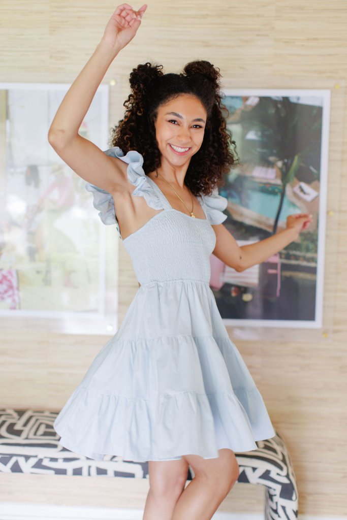 Dusty blue tiered mini dress with ruffle cap sleeve and adjustable button straps